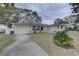 Front view of the house with a driveway at 553 Lake Hill Ln, Largo, FL 33771