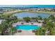 An aerial view of the community's large swimming pool and surrounding lounging area by the lake at 6645 Current Dr, Apollo Beach, FL 33572