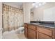 Bathroom with tub shower combo, wood cabinets and granite countertop at 6645 Current Dr, Apollo Beach, FL 33572