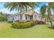 Landscaped front yard with palm trees and a two-story house at 6645 Current Dr, Apollo Beach, FL 33572