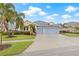 Two-story house with blue siding, three-car garage, and palm trees at 6645 Current Dr, Apollo Beach, FL 33572