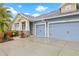 Three-car garage with blue siding and stone accents at 6645 Current Dr, Apollo Beach, FL 33572