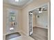 A tiled entry foyer with glass paneled door, next to a room with wood flooring at 6645 Current Dr, Apollo Beach, FL 33572