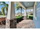 Welcoming front porch with stone-clad pillars, a brick-paved walkway, and lush tropical landscaping adding curb appeal at 6645 Current Dr, Apollo Beach, FL 33572