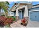 Inviting front porch with stone accents, white columns, manicured landscaping, and a brick pathway leading to the entrance at 6645 Current Dr, Apollo Beach, FL 33572