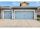 Close-up of a two-car garage with a well-kept concrete driveway, stylish carriage doors, and decorative outdoor lighting at 6645 Current Dr, Apollo Beach, FL 33572