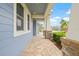 Brick paved porch with stone columns and a red door at 6645 Current Dr, Apollo Beach, FL 33572