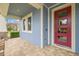 Red front door and covered porch with tiled floor at 6645 Current Dr, Apollo Beach, FL 33572