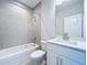 Bathroom with shower/tub combo, white vanity and gray tile at 7773 93Rd N St # 31, Seminole, FL 33777