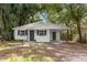 Charming bungalow with white exterior, covered carport, and well-manicured lawn at 803 E North St, Tampa, FL 33604