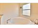 Relaxing bathroom with a spacious soaking tub and a window at 803 Innergary Pl, Valrico, FL 33594