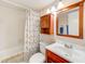 Traditional bathroom featuring a tub-shower, vanity, medicine cabinet, and wooden frame mirror at 90 S Highland Ave # 7, Tarpon Springs, FL 34689