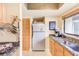 Cozy kitchen featuring stainless steel refrigerator, granite countertops, and light-colored cabinets at 90 S Highland Ave # 7, Tarpon Springs, FL 34689