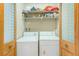 Convenient laundry area with a washer, dryer, and practical shelving for storage at 90 S Highland Ave # 7, Tarpon Springs, FL 34689