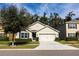 Beige house with a two-car garage and a well-maintained lawn at 10029 Warm Stone St, Thonotosassa, FL 33592