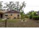 View of home's rear elevation, showcasing landscaping at 1018 E Hanna Ave, Tampa, FL 33604