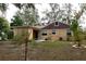 View of home's rear, showcasing landscaping and shed at 1018 E Hanna Ave, Tampa, FL 33604