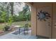 Small patio area with chair and table, view of backyard at 1018 E Hanna Ave, Tampa, FL 33604