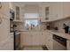 Bright kitchen with white cabinets, stainless steel appliances, and a window overlooking the backyard at 1018 E Hanna Ave, Tampa, FL 33604