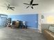 Bright living room with blue walls, laminate floors, and ceiling fans at 10537 Sky Flower Ct, Land O Lakes, FL 34638