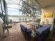 Relaxing screened patio overlooking a lake with seating and a table at 10537 Sky Flower Ct, Land O Lakes, FL 34638