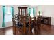 Dining area features a wood table, chairs, hutch, and teal curtains at 10538 Bay Hills Cir, Thonotosassa, FL 33592