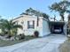 Front view of a mobile home with carport, American flag, and landscaped yard at 10538 Bay Hills Cir, Thonotosassa, FL 33592