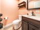 Modern bathroom with dark vanity, white toilet, and peach colored walls at 1080 Buena Vista Ave, Brooksville, FL 34601