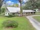 Charming one-story home with stone facade, metal roof, and large oak trees at 1080 Buena Vista Ave, Brooksville, FL 34601