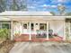 Inviting front porch with tiled flooring, white columns, and comfortable seating at 1080 Buena Vista Ave, Brooksville, FL 34601