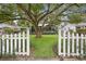 House exterior featuring a white picket fence and lush lawn at 1217 E Flora St, Tampa, FL 33604