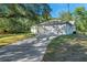 House exterior showcasing a long driveway and green lawn at 12240 Eakin St, Weeki Wachee, FL 34614