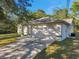 Front view of the house, showcasing a white exterior and garage at 12240 Eakin St, Weeki Wachee, FL 34614