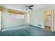 Spacious bedroom with light teal carpet and ceiling fan at 13000 Club Dr, Hudson, FL 34667