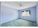 Light blue bedroom with teal carpet and ceiling fan at 13000 Club Dr, Hudson, FL 34667