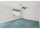 Bright living room featuring teal carpet and a ceiling fan at 13000 Club Dr, Hudson, FL 34667