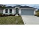 New single-story home with gray garage door and landscaping at 13299 Ogden Glade Rd, Dade City, FL 33525