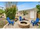 Charming backyard with firepit, blue chairs, and mature plantings at 1437 Park St, Clearwater, FL 33755