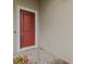 Red front door entry with a tiled stoop and small potted plant at 1575 N River Cir, Tarpon Springs, FL 34689