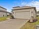 Tan colored two-car garage with a paved driveway at 1575 N River Cir, Tarpon Springs, FL 34689