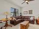 Living room with a brown leather sectional sofa and ceiling fan at 1575 N River Cir, Tarpon Springs, FL 34689