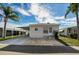 Tan single-wide manufactured home with carport and landscaped yard at 18675 Us Highway 19 N # 364, Clearwater, FL 33764