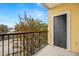 Private balcony with storage and metal railing overlooking a tree-lined street at 1910 E Palm Ave # 8214, Tampa, FL 33605