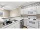 White kitchen with appliances and wood floors at 1910 E Palm Ave # 8214, Tampa, FL 33605