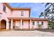 Pink stucco house with covered patio and landscaping at 1962 Freedom Dr, Clearwater, FL 33755