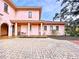 Pink house with covered patio and brick driveway at 1962 Freedom Dr, Clearwater, FL 33755