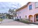 Pink stucco house with paver driveway and landscaping at 1962 Freedom Dr, Clearwater, FL 33755