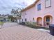 Pink house with a brick driveway and garage at 1962 Freedom Dr, Clearwater, FL 33755