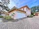 Two-car garage with white doors and paver driveway at 1962 Freedom Dr, Clearwater, FL 33755