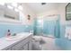 Light blue tiled bathroom with tub, toilet, and vanity at 2071 Australia W Way # 17, Clearwater, FL 33763